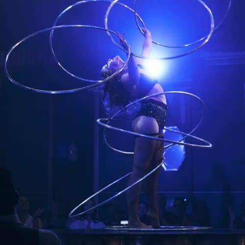 Jess Mews spins hula hoops under blue lights